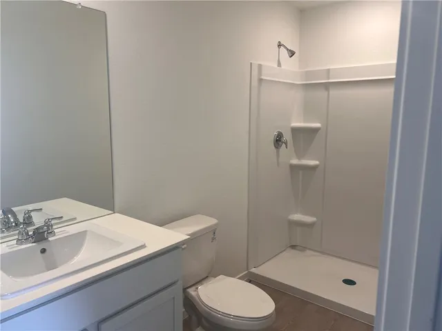 a bathroom with a sink a toilet and shower