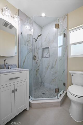 a bathroom with a shower sink mirror and toilet