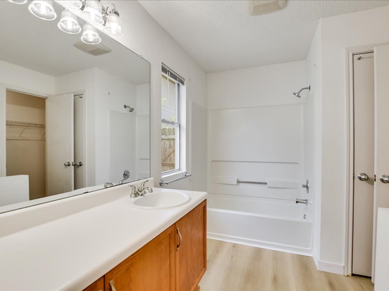 13827 Spring Heath Road Pflugerville, TX 78660 - Photo 15 of 20 A well-lit bathroom features a vanity, full-width mirror, and a tub-shower combination.