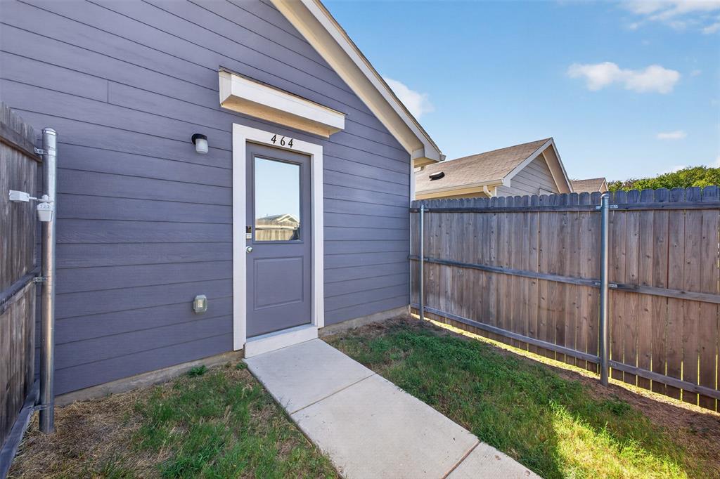 464 Reverie Way Ferris, TX 75125 - Photo 27 of 36 Siding exterior with a gable roof, featuring a single entry door with an overhead light fixture