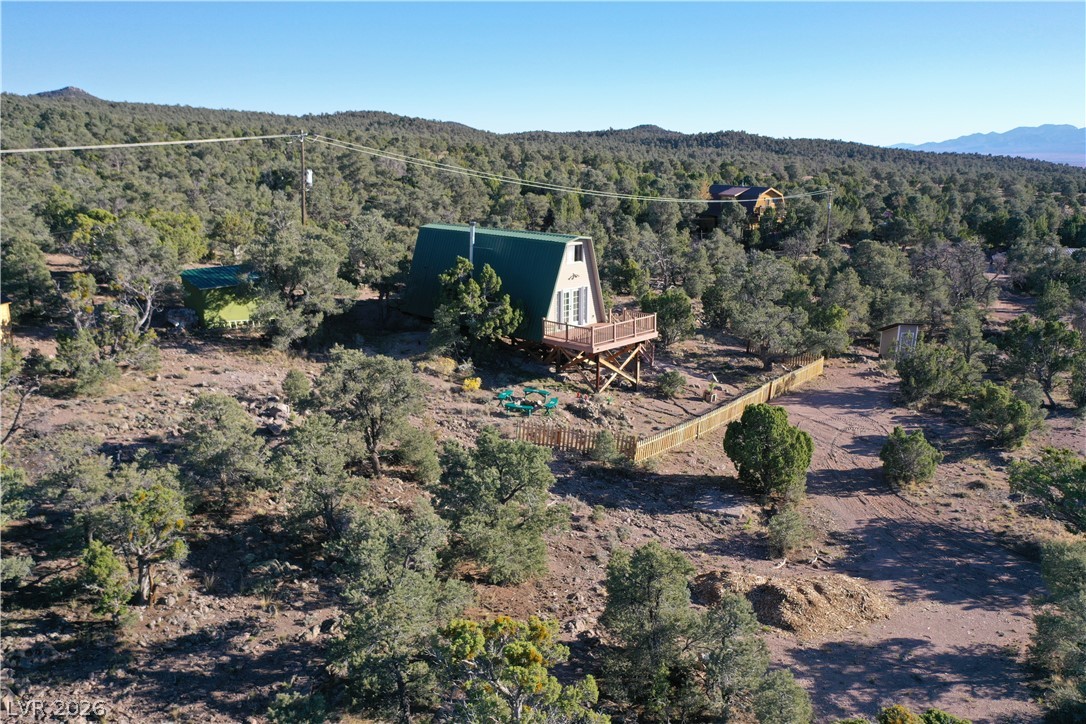 20502 Windsong Road Pioche, NV 89043 - Photo 29 of 30 An elevated wooden deck extends from this unique A-frame cabin surrounded by natural terrain.