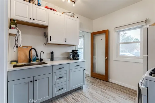 a kitchen with stainless steel appliances granite countertop a sink cabinets and wooden floor