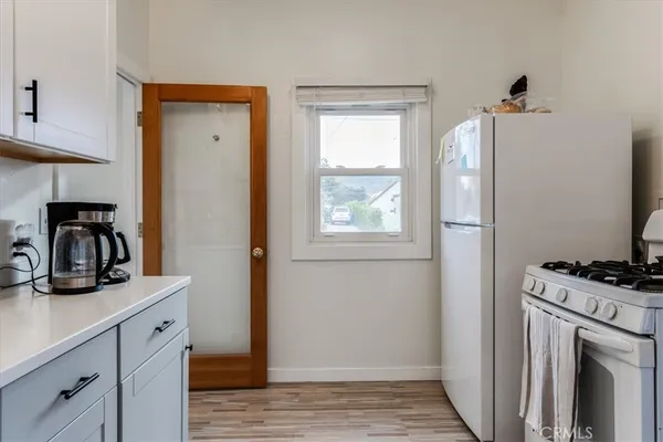 a kitchen with a refrigerator and a stove top oven