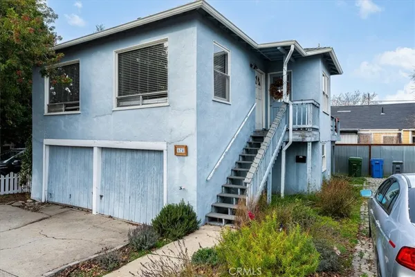 a front view of a house with stairs and windows