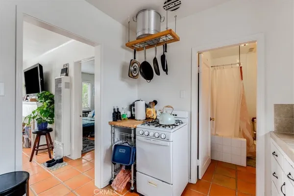 a kitchen with stainless steel appliances granite countertop a stove a refrigerator and a dining table with wooden floor