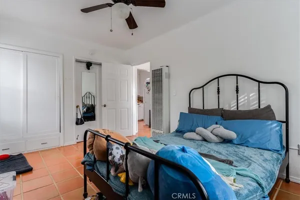 a bedroom with a bed a chandelier and dresser