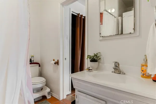 a bathroom with a sink a toilet and shower curtain