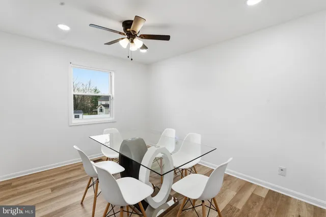 a view of a dining room with furniture and a chandelier fan