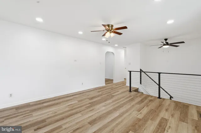 a view of a room with wooden floor and a ceiling fan