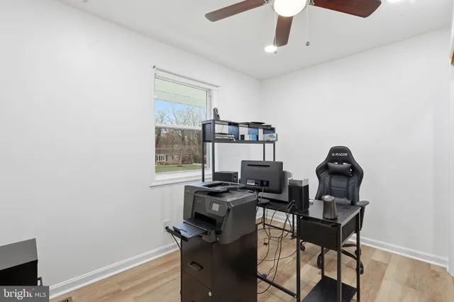 a view of a workspace with furniture and a window