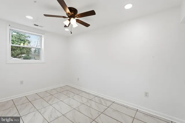 an empty room with a window and a fan