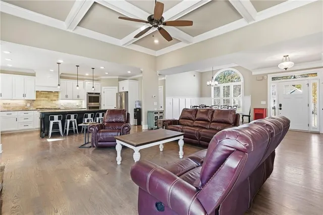 a living room with furniture kitchen view and a large window