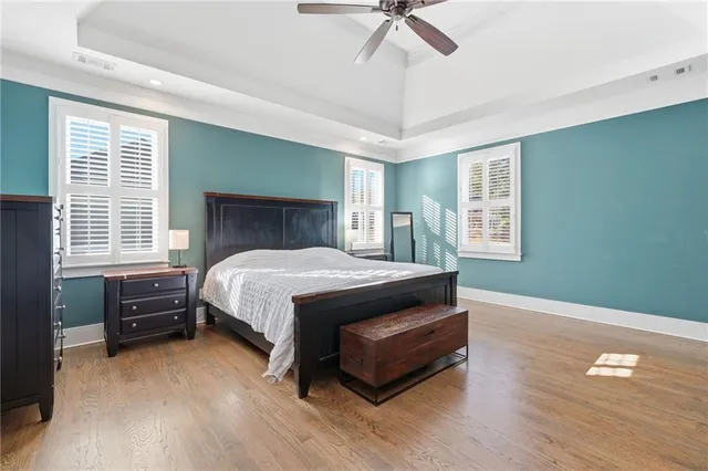 a bed sitting in a spacious bedroom next to a window