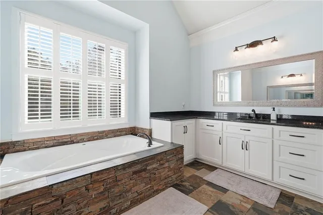 a spacious bathroom with a granite countertop tub and a sink
