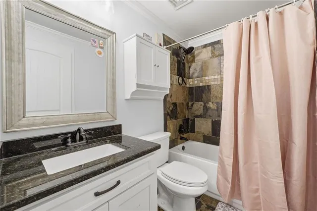 a bathroom with a granite countertop sink toilet and shower