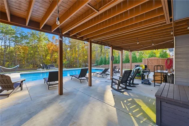 a swimming pool with outdoor seating and yard