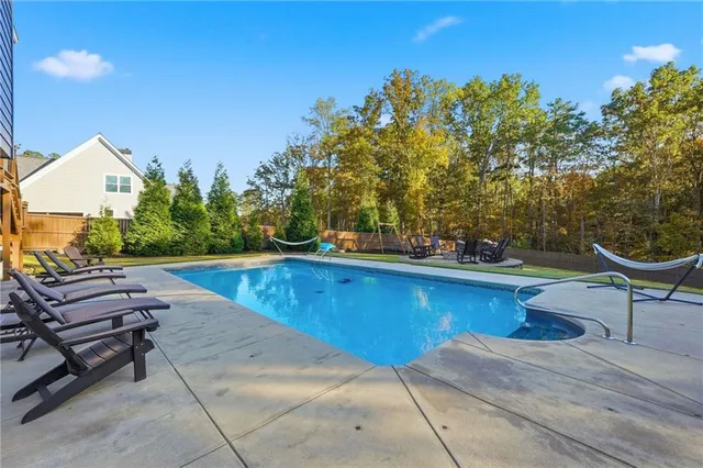 a front view of a house with swimming pool having outdoor seating