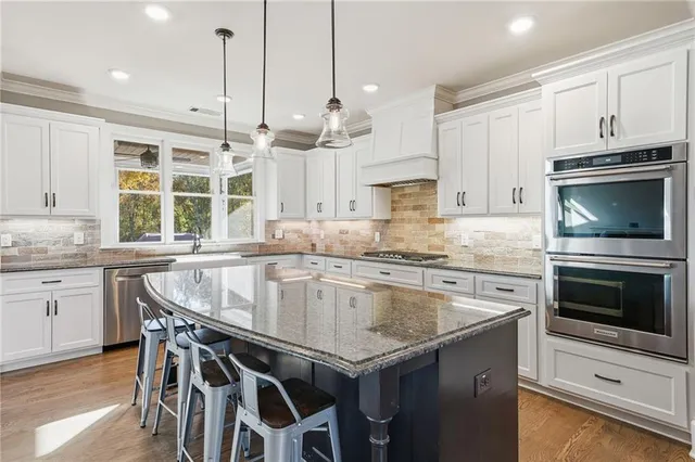 a kitchen with stainless steel appliances granite countertop a stove a sink and a microwave