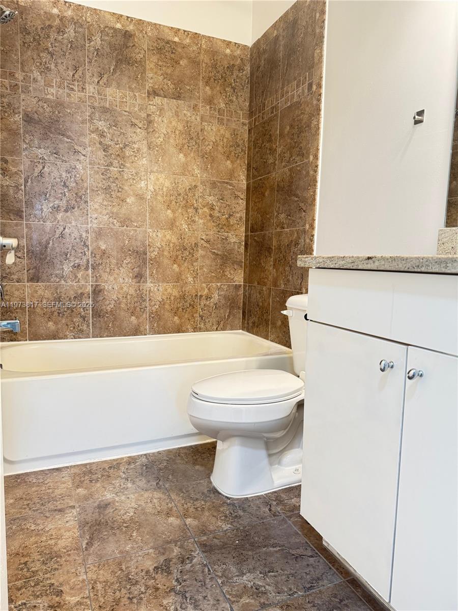 7658 Northwest 88th Terrace, Unit 12 Tamarac, FL 33321 - Photo 11 of 12 a bathroom with a toilet and a shower