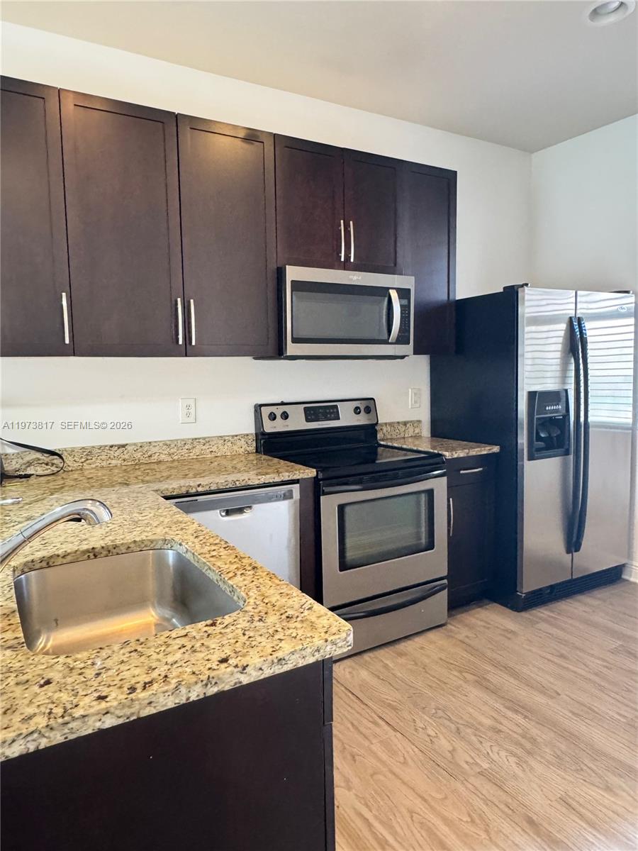 7658 Northwest 88th Terrace, Unit 12 Tamarac, FL 33321 - Photo 4 of 12 a kitchen with a sink stove and refrigerator