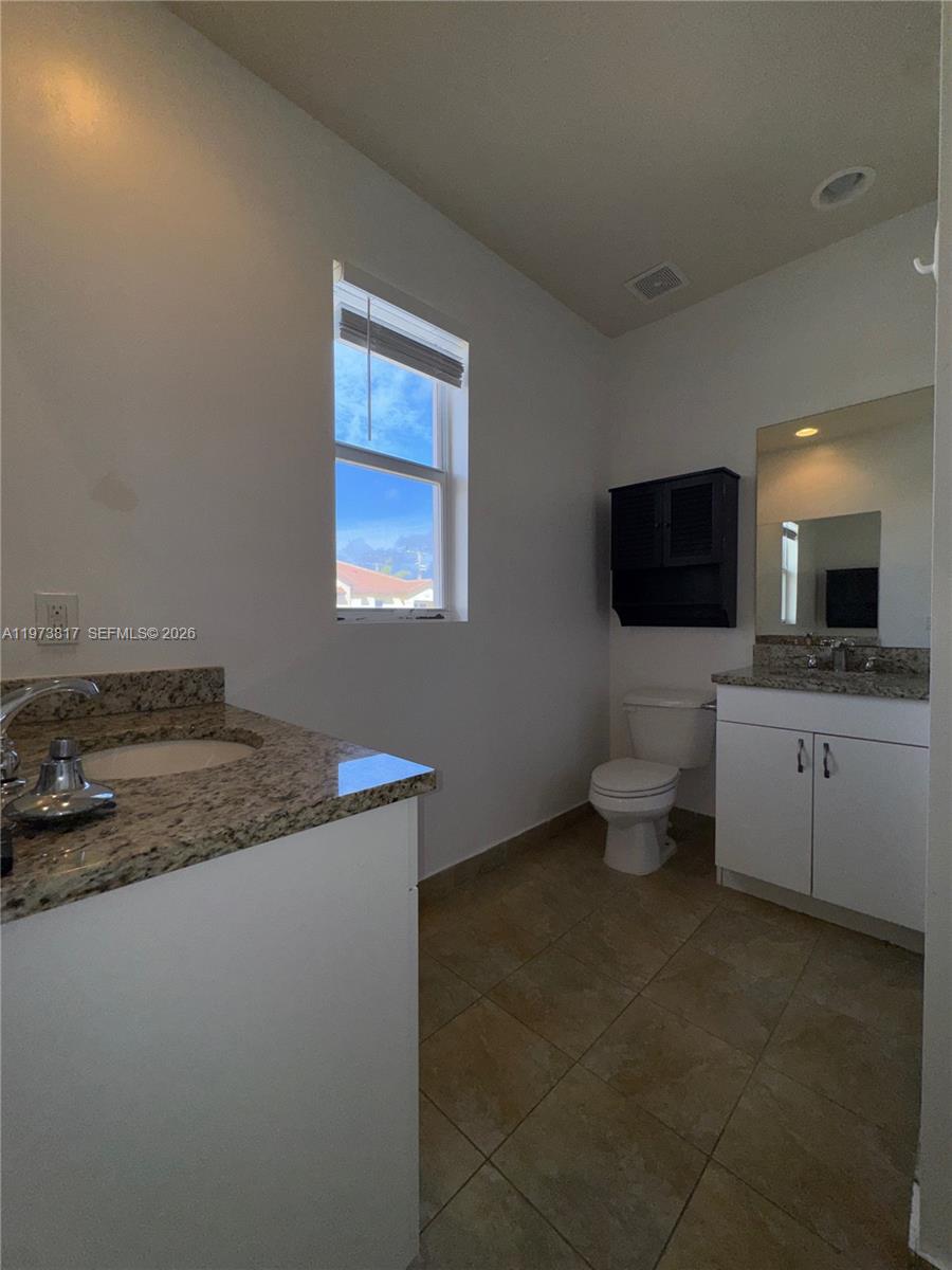 7658 Northwest 88th Terrace, Unit 12 Tamarac, FL 33321 - Photo 9 of 12 a kitchen with a sink a stove and microwave