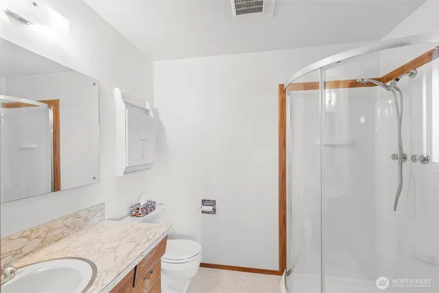 a bathroom with a granite countertop sink toilet and shower