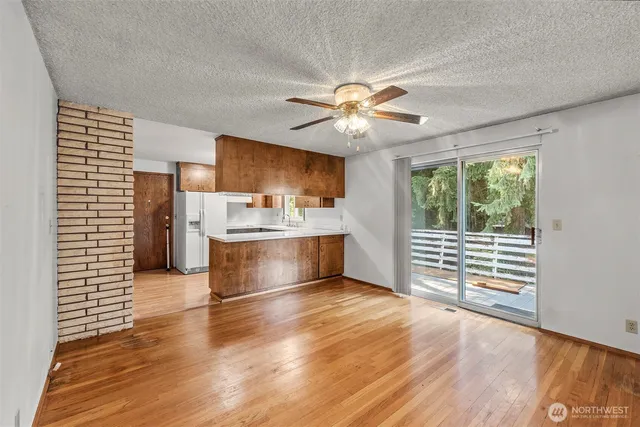 a view of open kitchen with wooden floor and a ceiling fan