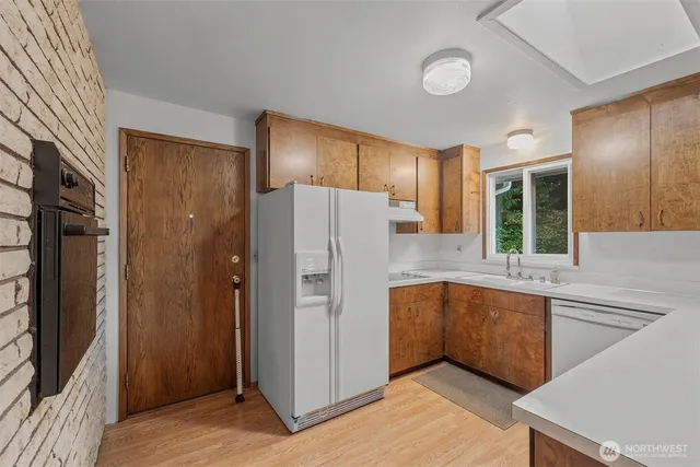 a kitchen with a refrigerator sink and cabinets