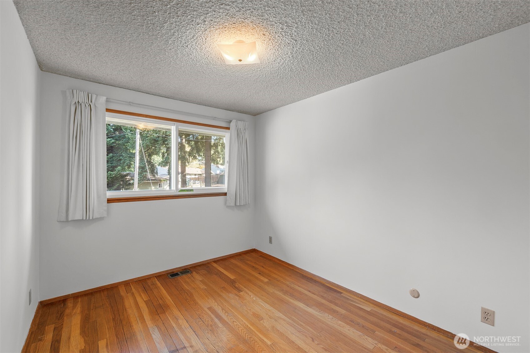 1027 South 112th Street Seattle, WA 98168 - Photo 10 of 33 a view of empty room with wooden floor and fan