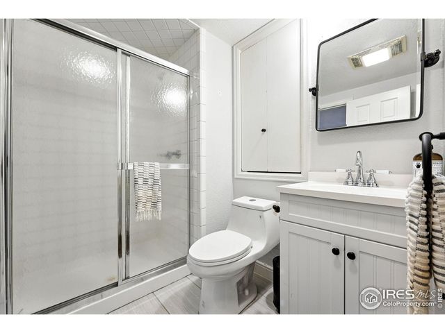 a bathroom with a toilet a sink a glass door a shower and a mirror