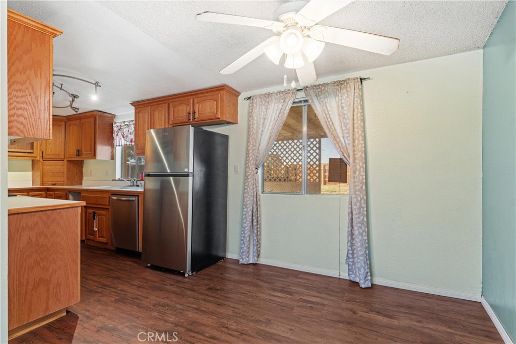 13445 Fran Street Edwards, CA 93523 - Photo 6 of 27 a view of a refrigerator in kitchen and an empty room with wooden floor