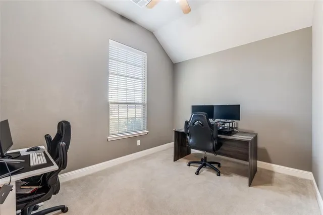 a view of a workspace with furniture and a window