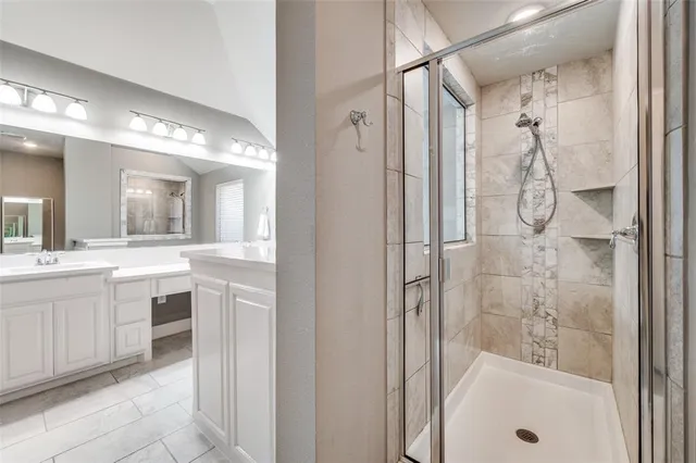 a bathroom with a double vanity sink mirror and shower