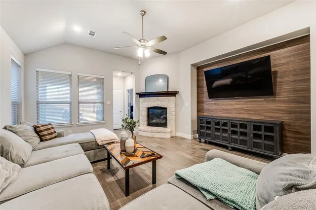 a living room with furniture a fireplace and a flat screen tv