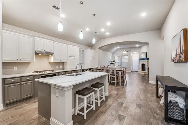 a kitchen with a stove a table and chairs in it