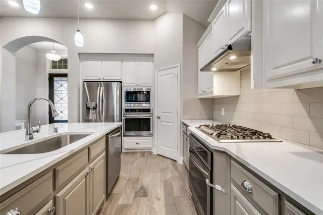 a kitchen with kitchen island stainless steel appliances a sink stove and refrigerator