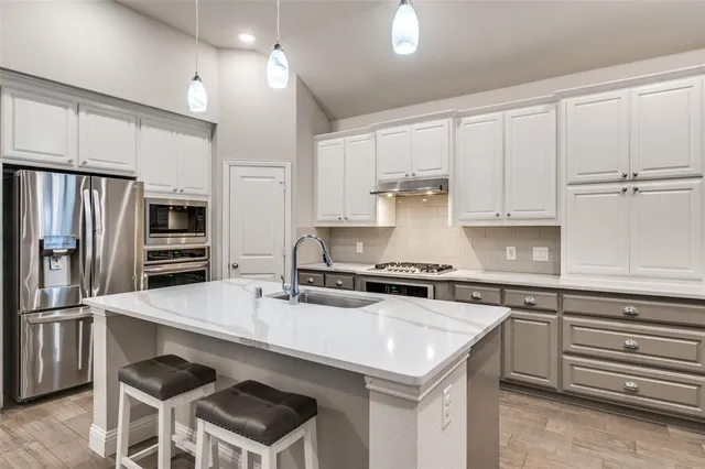 a kitchen with granite countertop a sink appliances and cabinets