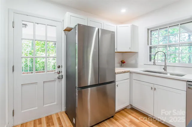 a kitchen with stainless steel appliances a refrigerator sink and cabinets
