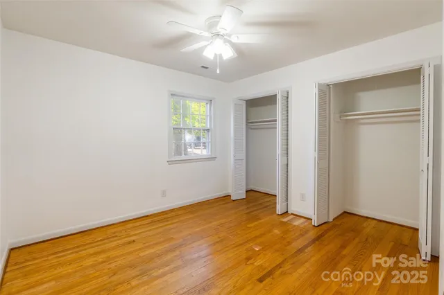a view of empty room with window and ceiling fan