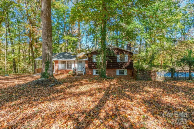 a view of a house with backyard and trees