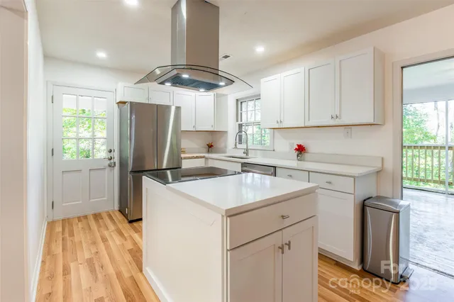 a kitchen with a sink a refrigerator a window and cabinets