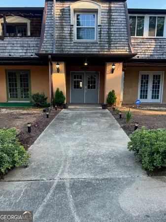 a front view of a house with garden and parking