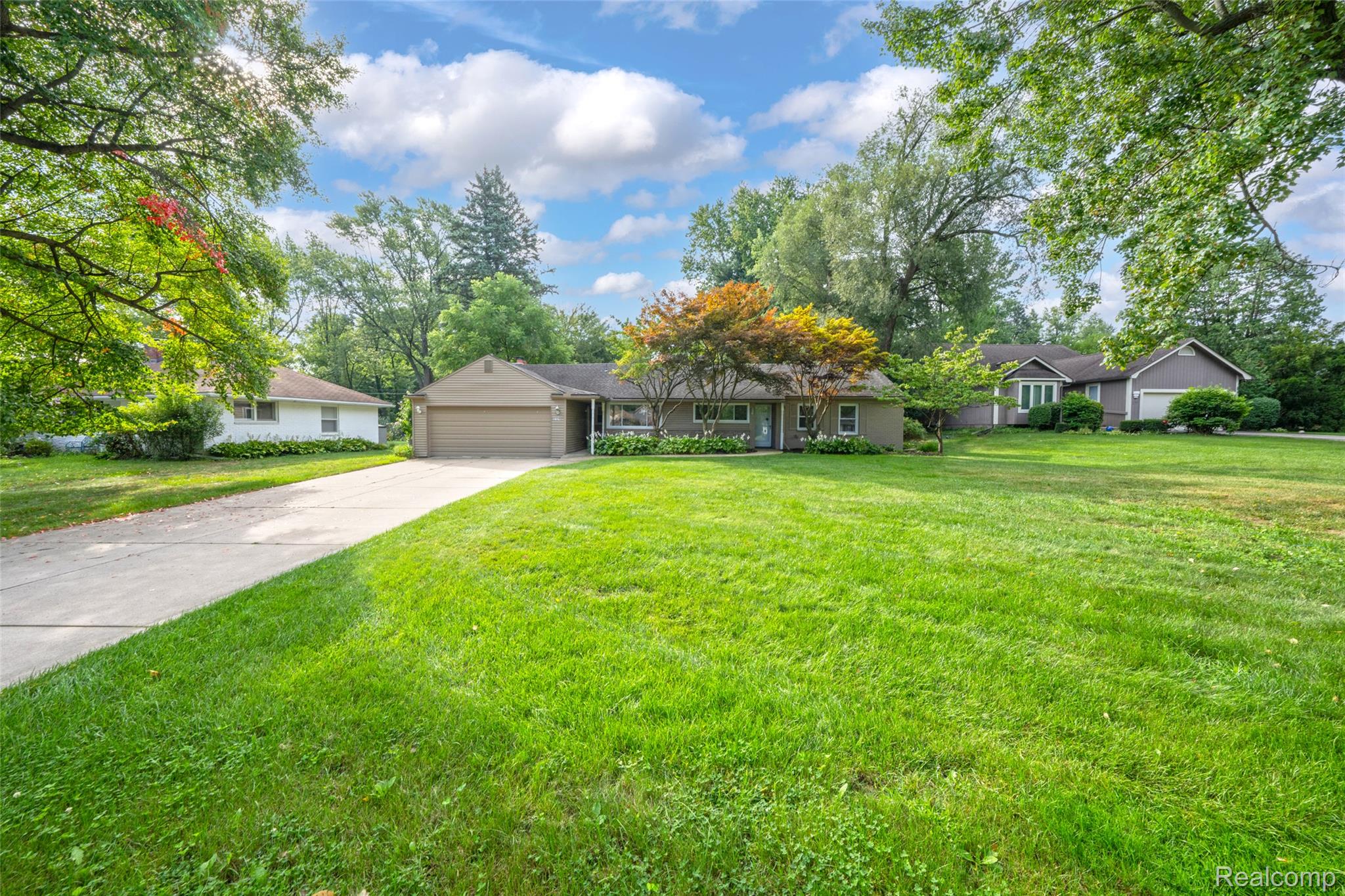 2329 Rutherford Road Bloomfield Hills, MI 48302 - Photo 4 of 46 Expansive front lawn with mature trees and a paved driveway leading to an attached garage