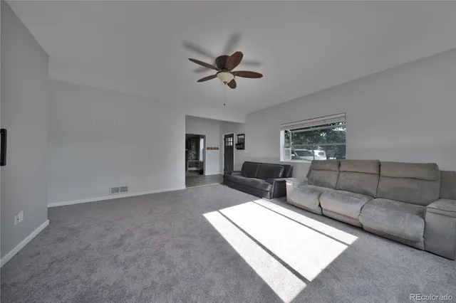a living room with furniture and a ceiling fan