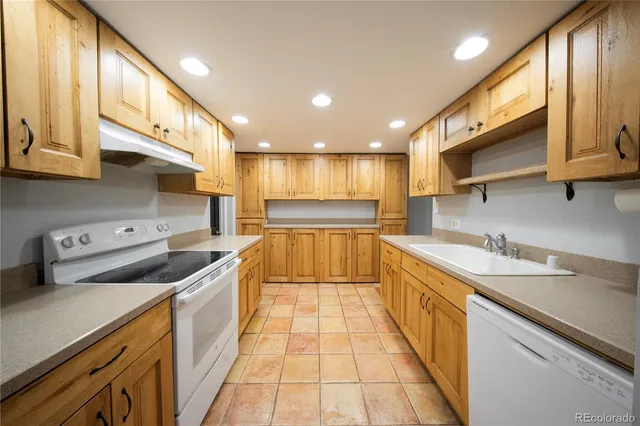 a kitchen with stainless steel appliances granite countertop a sink and a stove