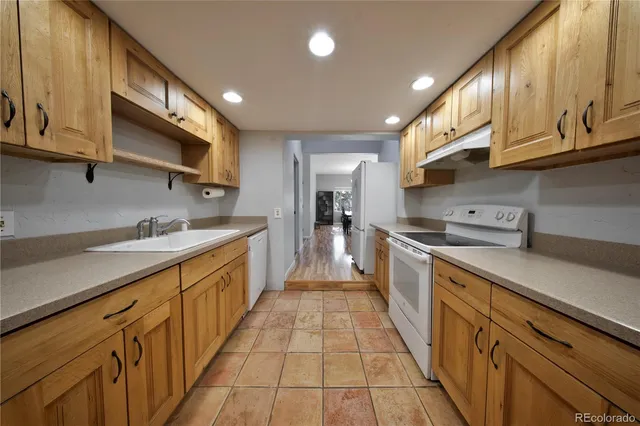 a large kitchen with stainless steel appliances granite countertop a stove a sink and a microwave