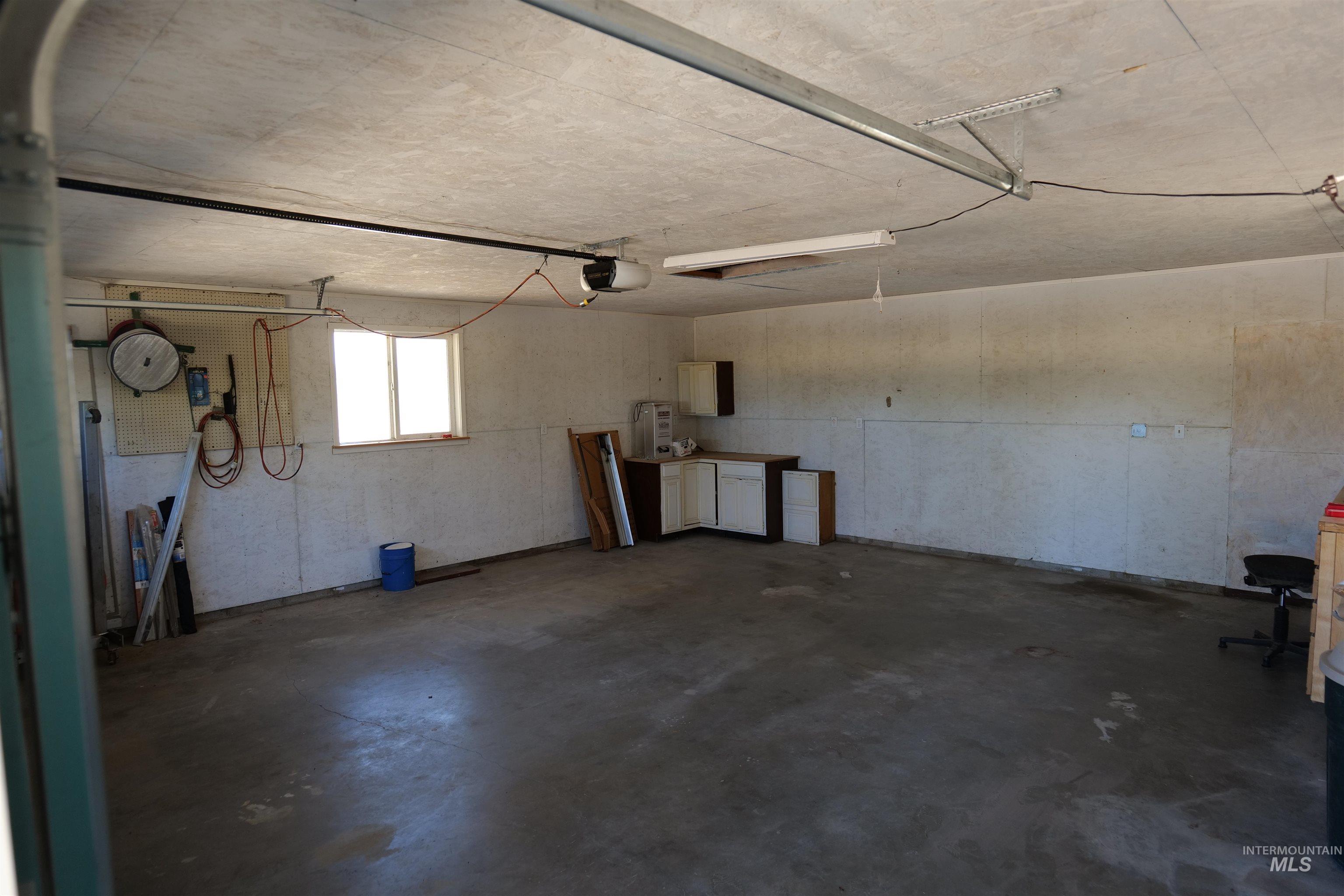 1485 East 9th Street Weiser, ID 83672 - Photo 11 of 18 Spacious garage featuring concrete flooring, built-in cabinetry, and a double-paned window for natural light