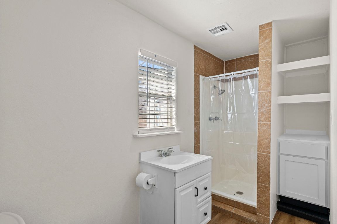 13415 Crane Road Buda, TX 78610 - Photo 22 of 22 Full bath featuring a shower stall, vanity, and dark wood finished floors