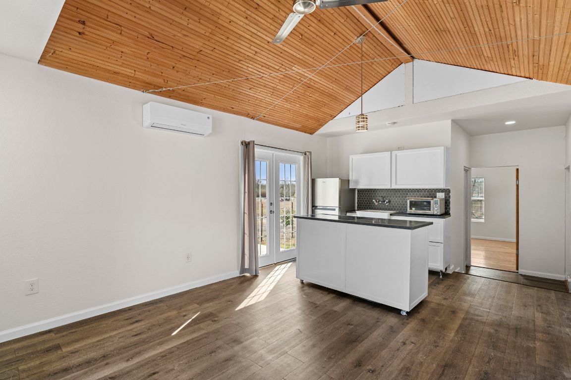 13415 Crane Road Buda, TX 78610 - Photo 4 of 22 Kitchen featuring a wood ceiling with exposed beams, white cabinets, french doors, dark countertops, and a center island