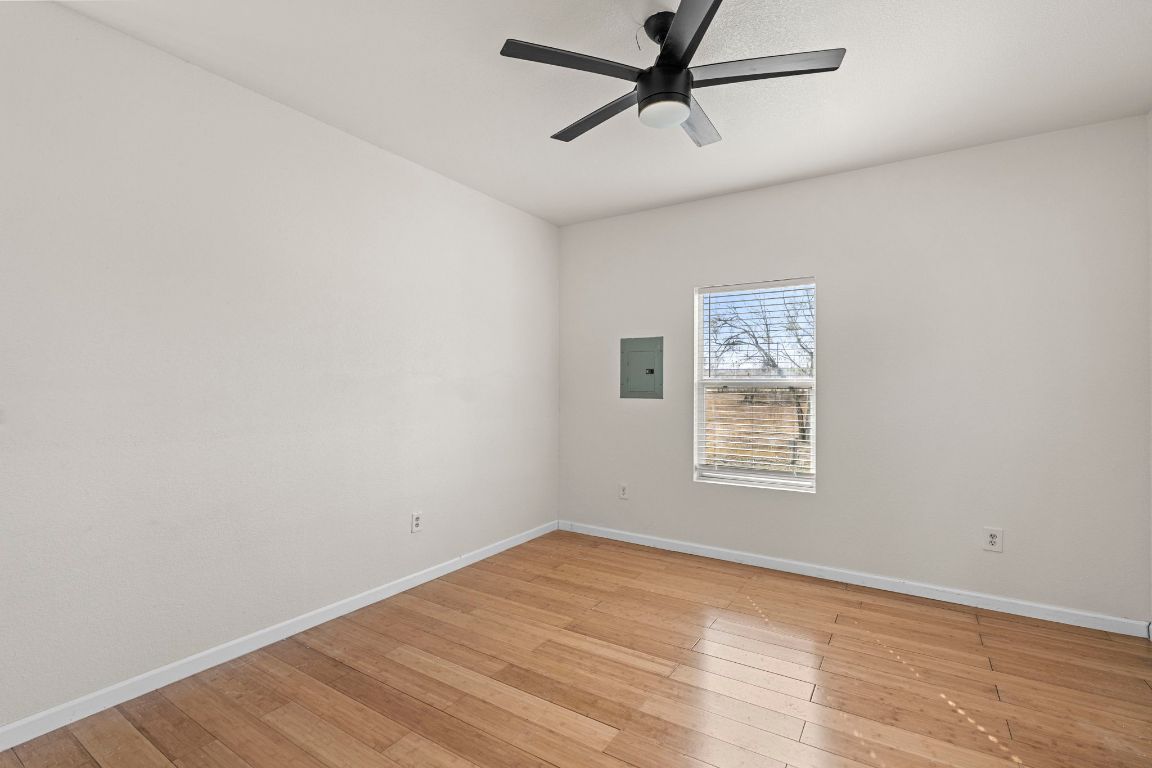 13415 Crane Road Buda, TX 78610 - Photo 8 of 22 Unfurnished room featuring light wood-style flooring, a ceiling fan, and electric panel